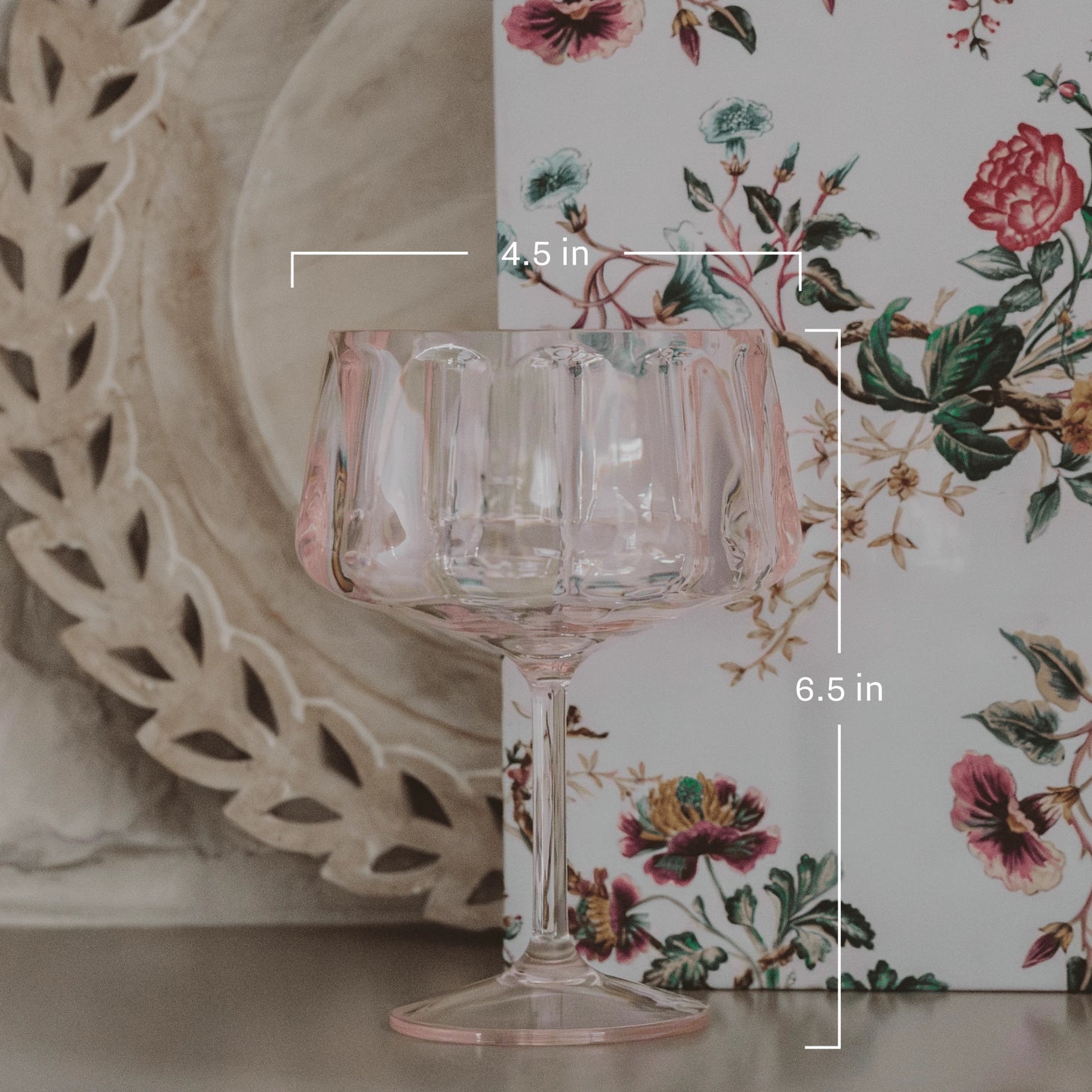 Clear glass goblet with floral design in the background