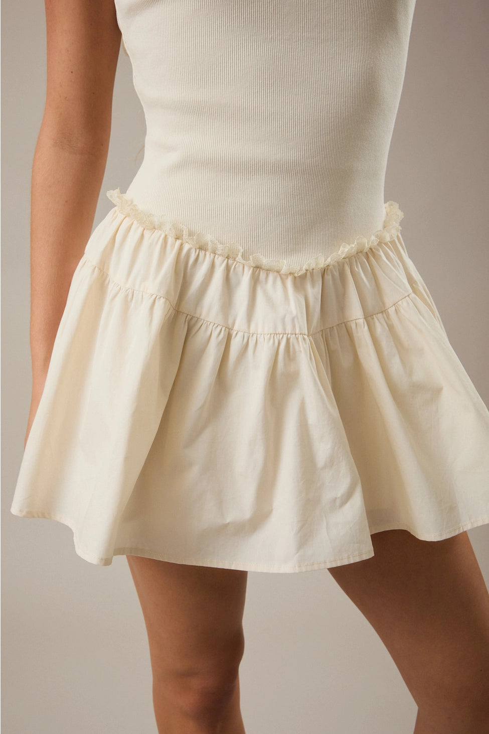 White skirt worn by a person on a neutral background