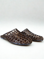 Pair of woven brown sandals on a white background