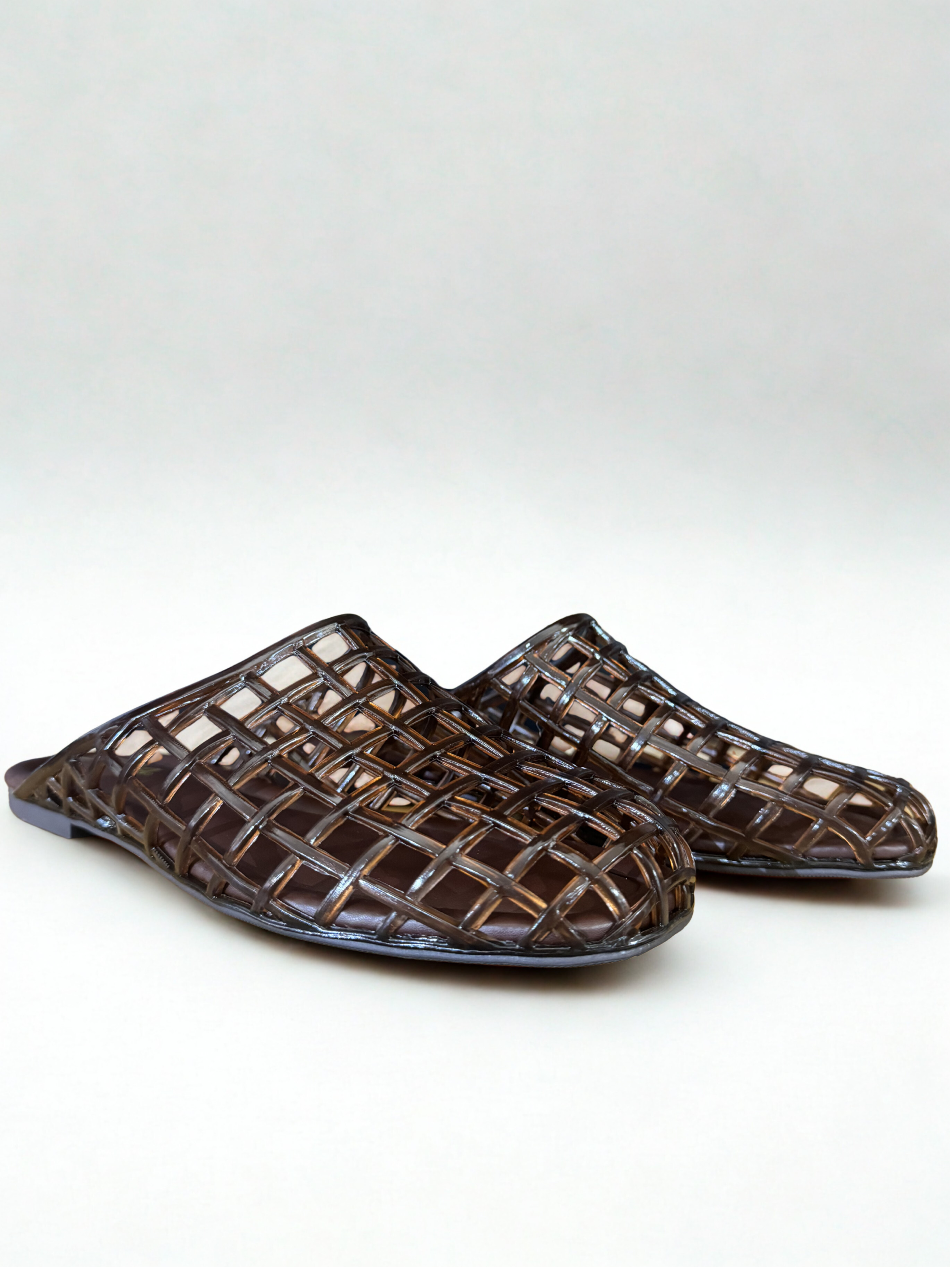 Pair of woven brown sandals on a white background